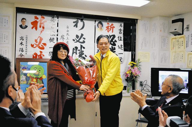 支援者から笑顔で花束を受け取る吉住さん（右）＝新宿区で