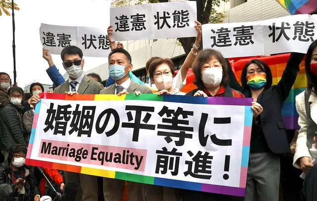 同性婚を巡る訴訟の判決後、東京地裁前で「婚姻の平等に前進！」と書かれた紙を掲げる原告ら