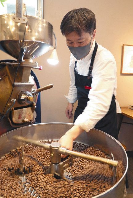 焙煎したコーヒー豆の状態を確認する高橋史郎さん＝東京都台東区で

