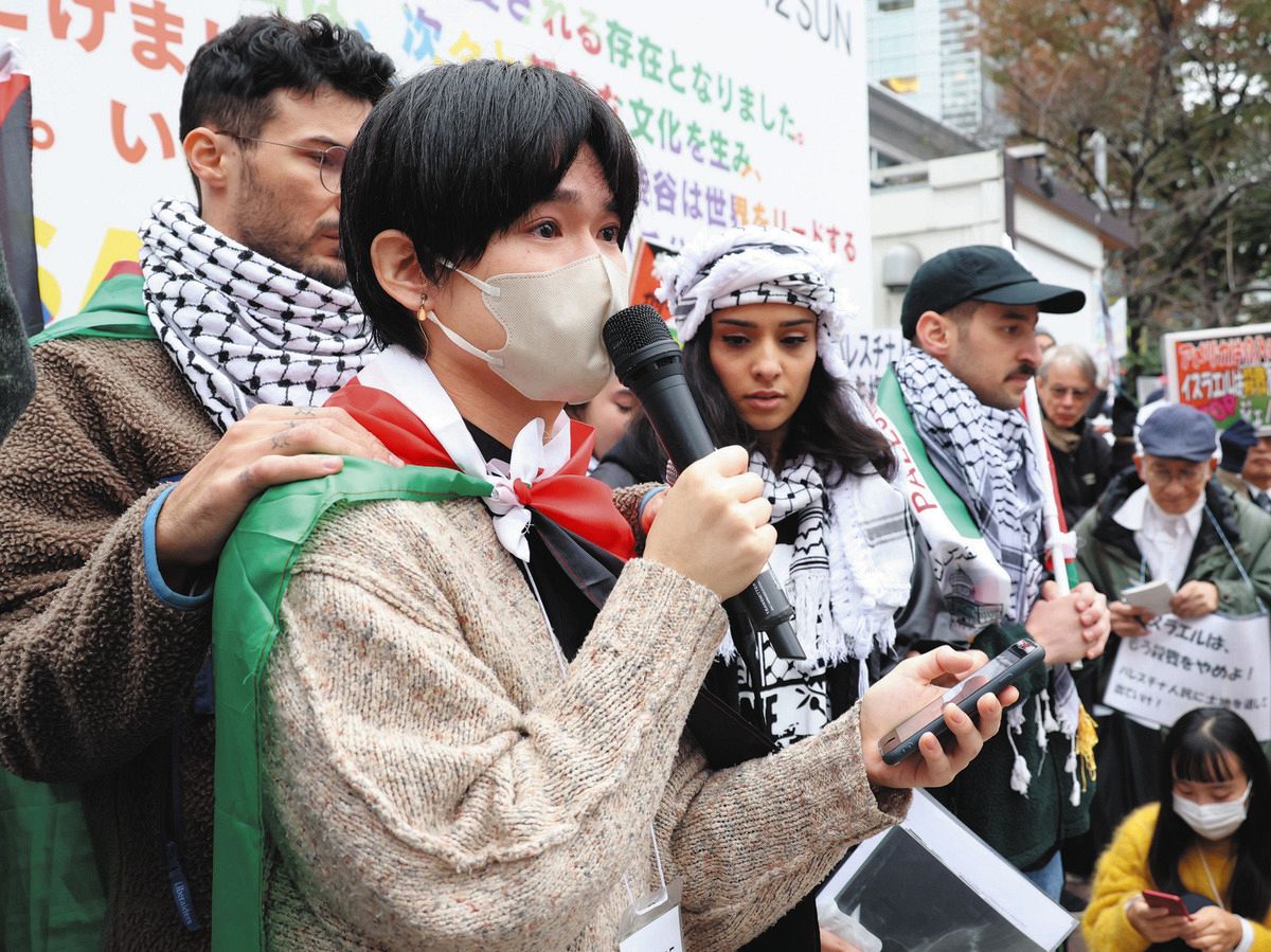 デモで通訳をする松下新土さん。中央の女性がハニンさん＝12日、東京都渋谷区で