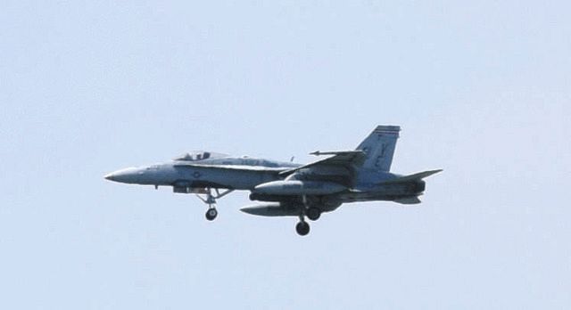 8月、沖縄県宜野湾市の市街地上空を飛行するFA18戦闘攻撃機。普天間飛行場に着陸した＝同市提供