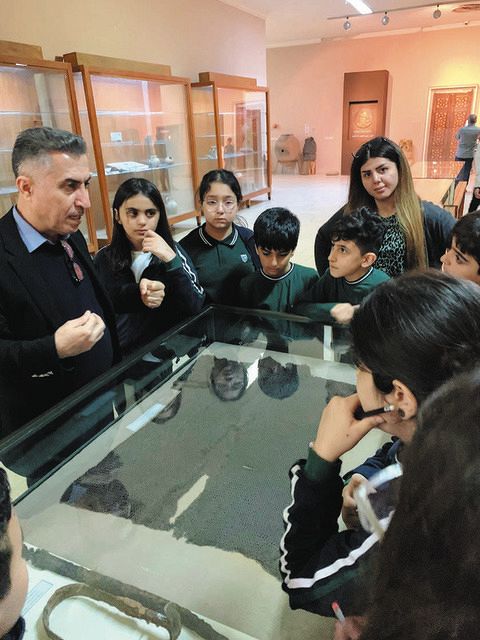 15日、イラク北東部スレイマニヤの博物館で、クルドの歴史について子どもたちに説明するアブドラ館長（左）