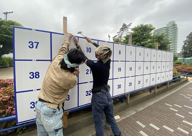 ３面分のポスター掲示板を増設する作業員たち＝東京都葛飾区東新小岩で