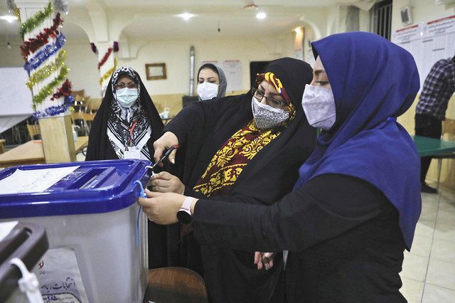 イラン大統領選の投票箱を開ける選管職員＝１９日、テヘランで（ＡＰ）