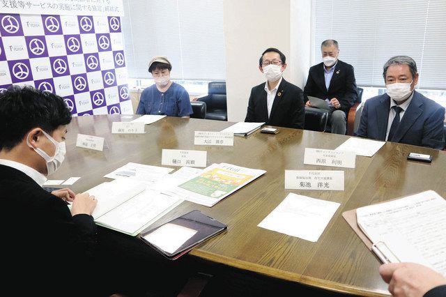 樋口区長（手前左）と話す認証や協定締結した企業代表ら＝千代田区役所で