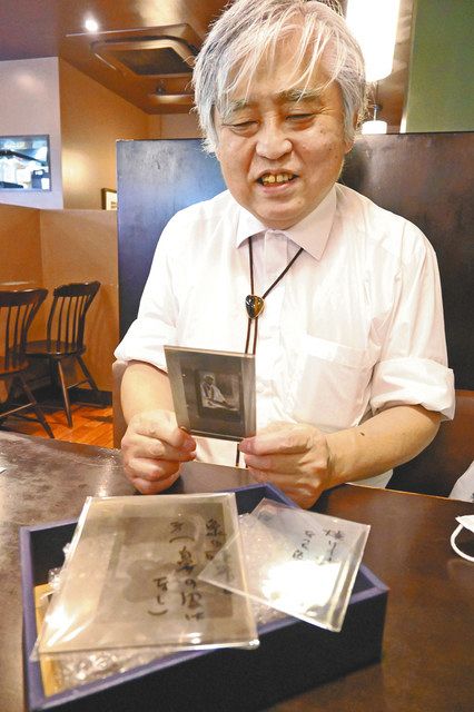 「ゾウの大旅行」に掲載した写真のガラス乾板を手に、父清之介さんについて語る小林洋介さん＝町田市で