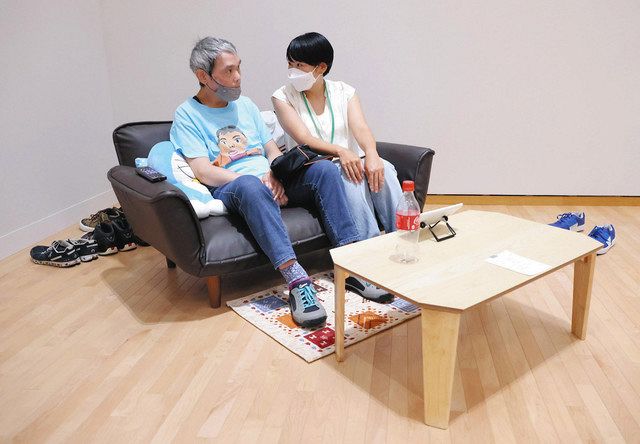 自身の一人暮らしの様子を題材にした作品のソファに座る尾野一矢さん㊧と工藤春香さん＝いずれも東京都江東区で
