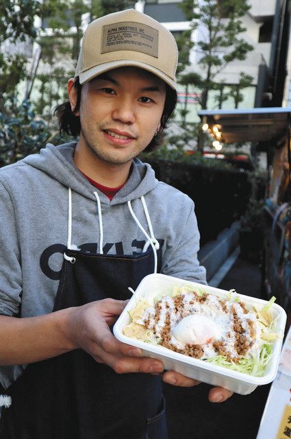 子ども食堂で提供するタコライスを手にする店長の殿岡さん＝渋谷区で