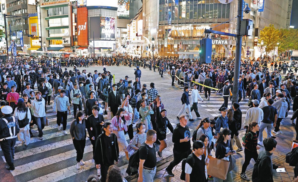 警察が交通整理に当たる中、若者らが行き交う渋谷駅前のスクランブル交差点＝28日、東京都渋谷区で