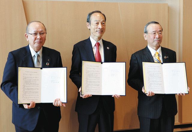 協定書を手に撮影に応じる（左から）望月理事長、武井区長、篠理事長＝港区芝５で