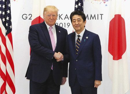 トランプ米大統領（左）との会談で握手する安倍首相＝２８日午前、大阪市で（代表撮影）