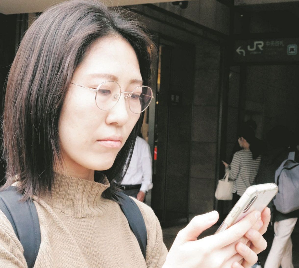 スマートフォンで鉄道を使った移動方法を確かめる相良さん