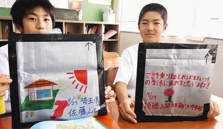 生徒が手作りしたアシスト瓦。被災者を励ますメッセージや、再建後をイメージした絵を添えた＝入間市立藤沢中学校で