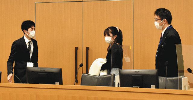 法廷内の裁判官席について案内役の裁判官（左）から説明を受けるツアーの参加者ら＝千葉地裁で
