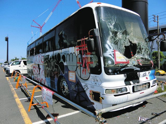 窓ガラスが割られ、車体に落書きされている大型バス（一部画像処理）＝いずれも川崎区の東扇島東公園で
