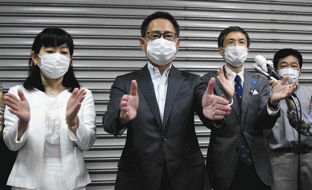感染予防のため万歳はせず、三本締めで当選を喜ぶ石島秀起さん（左から２番目）＝中央区で