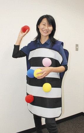 「ペガーボール」の鬼役のポンチョを着た青柳直美さん。参加者は逃げ回る鬼役のポンチョに、４色のボールを投げたり、くっつけたりする