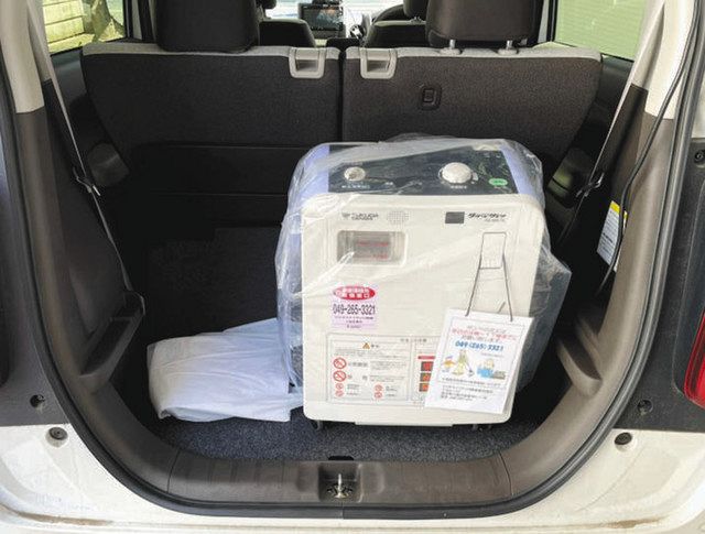 酸素濃縮器を車に積み、症状が悪化した患者の自宅まで届けている