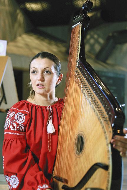 民族楽器バンドゥーラを手に、ウクライナの状況を話すカテリーナさん＝東京・内幸町の中日新聞東京本社で