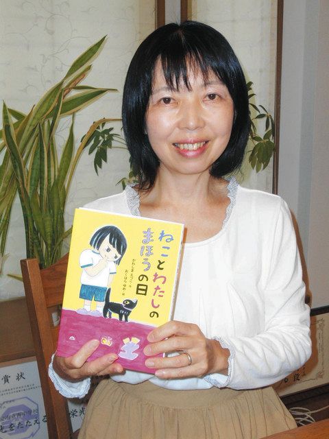 新作「ねことわたしのまほうの日」を手にする作者のかわしまえつこさん＝太田市で 