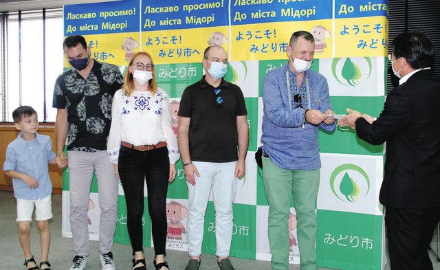 支援金を受け取るウクライナからの避難民５人と、須藤市長（右）＝みどり市で
