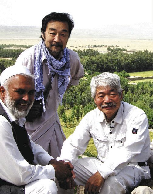 中村哲さん（右）の尽力でよみがえった緑を背に写真に納まる谷津賢二さん（上）（２０１９年４月撮影）＝アフガニスタンで、谷津賢二さん提供
