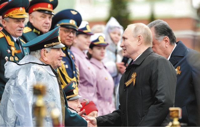 昨年５月９日の対独戦勝記念式典で、退役軍人と握手するプーチン大統領（右）＝ロシア大統領府公式サイトから
