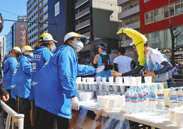 給水所で水のコップを並べる長竹祐子記者＝台東区で 