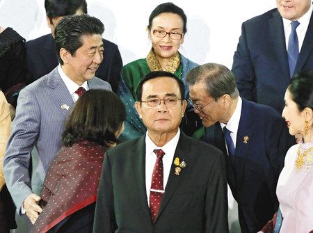 ＡＳＥＡＮ関連首脳らとの記念撮影で、韓国の文在寅大統領（右から２人目）とあいさつする安倍首相夫妻＝３日、バンコクで（代表撮影・共同）