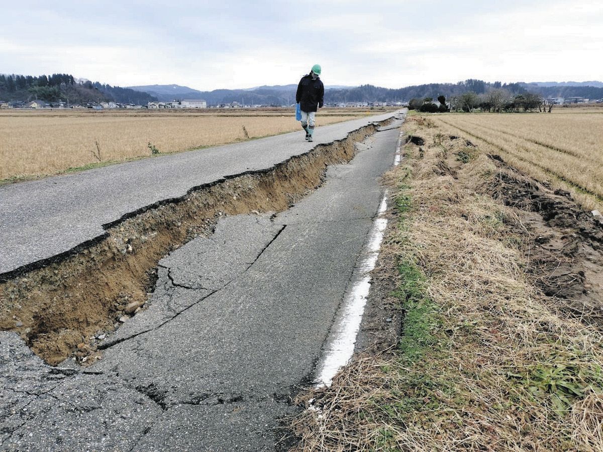 亀裂が入り最大65センチの段差が生じた農道。地下の農業用水パイプラインの損傷が懸念される＝富山県氷見市堀田で