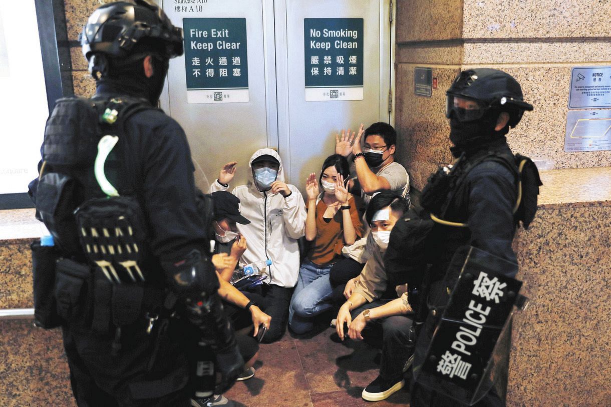 １日、香港中心部で警察に拘束された人たち＝ロイター・共同
