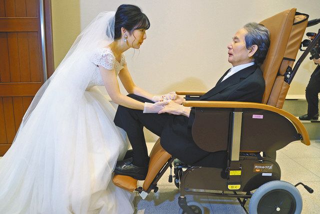 娘の上野美佳さん（左）の花嫁姿を見て感慨深げな父親の歯朶山孝男さん＝いずれも横浜市で