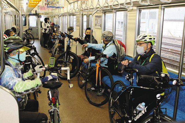 自転車ごと列車に乗り込むモニター参加者＝水戸駅で