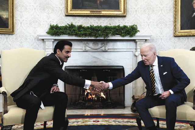 会談を前に握手するカタールのタミム首長（左）と米国のバイデン大統領＝１月３１日、米ホワイトハウス（AP） 