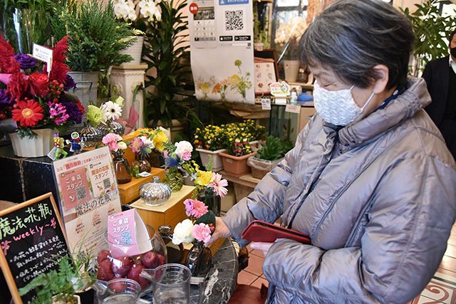 「柔らかい雰囲気の花が好き」と話しながら花を選ぶ女性＝名古屋市で
