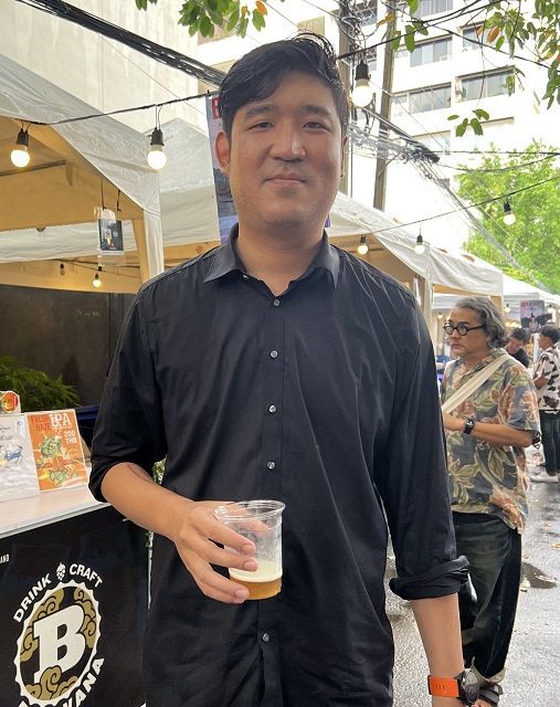 クラフトビールを片手に会場を歩くタオピポップ下院議員