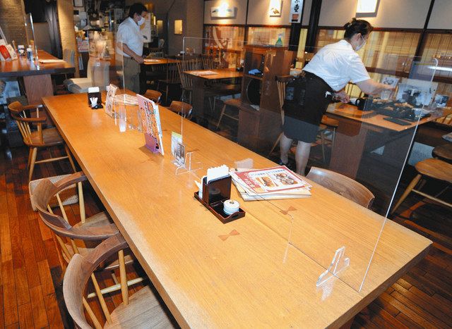 飲食店が感染防止のため大テーブルに設置した透明なついたて。座席数も減らしている

