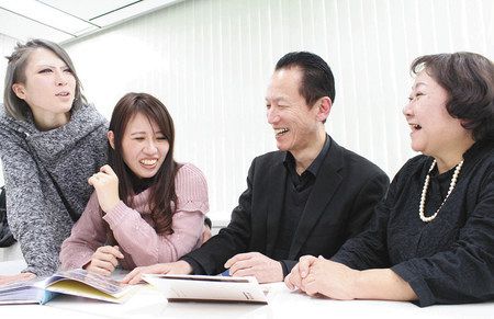 結婚式を挙げた（左から）宮川侑子さんと山野美都菜さん。父和男さんと母美恵子さんと昔の写真を見ながら笑顔があふれた＝東京都内で
