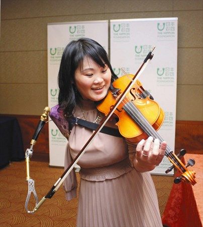 義手でバイオリンを弾く看護師、伊藤真波さん＝東京都港区で
