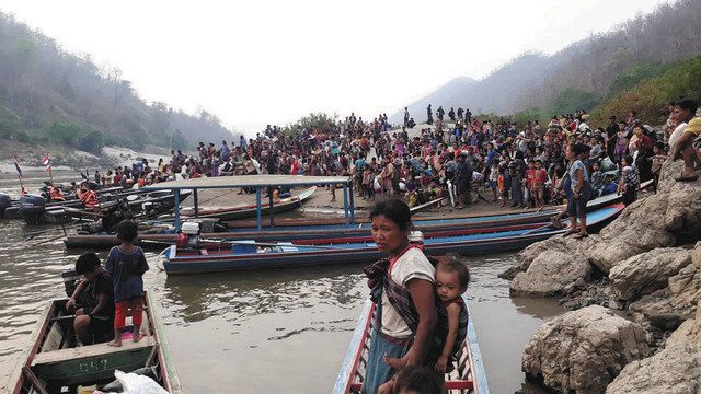 ２９日、ミャンマー・カイン州とタイの国境の川沿いで、国軍の空爆から逃れ、行き場を失ったたカレン族の家族ら＝現地住民撮影、支援団体提供