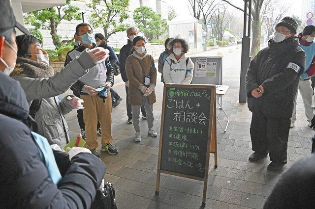 食料品配布の前に打ち合わせをするボランティアの人たち＝１月、いずれも東京都新宿区で