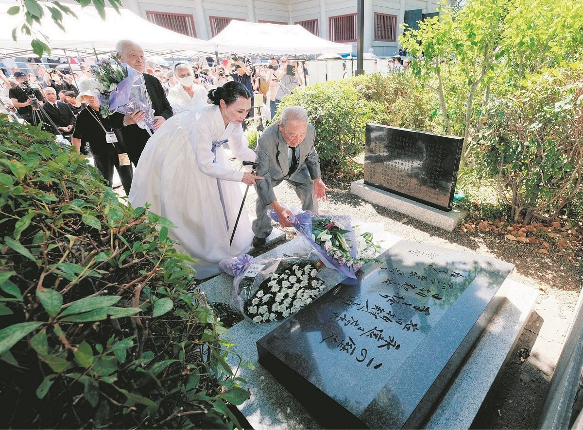 虐殺された朝鮮人を悼み、追悼碑前で開いた式典で献花する人＝9月、東京都墨田区で