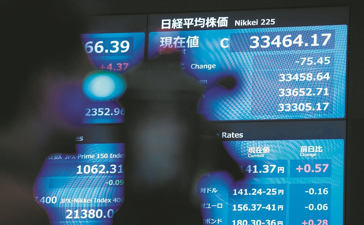年末の株価としては34年ぶりの高値となった日経平均株価3万3464円17銭を表示する東京証券取引所の株価ボード＝AP