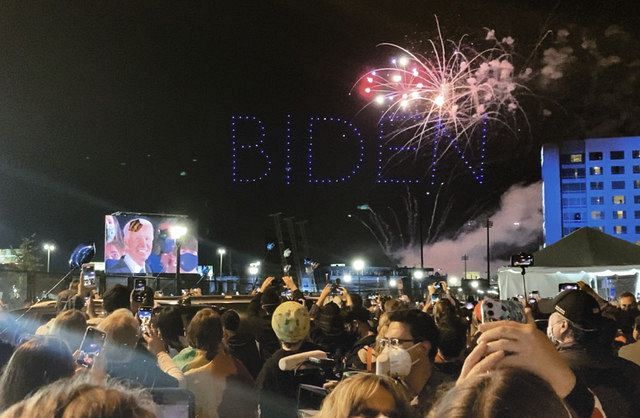 7日夜、バイデン氏が勝利演説をしたデラウェア州ウィルミントンの会場周辺で、花火を見上げる人々＝杉藤貴浩撮影
