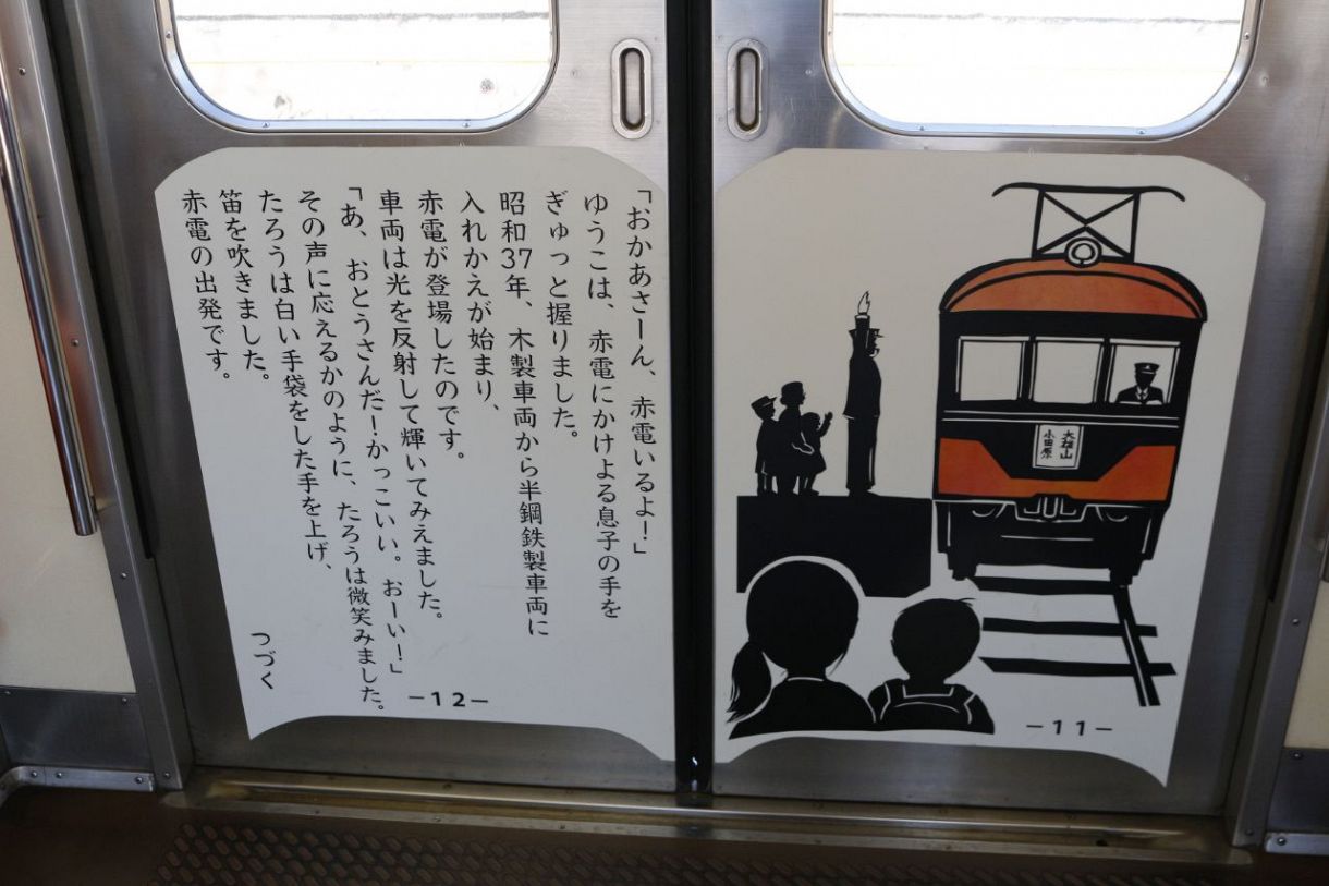 乗車した大雄山線の車両には、大雄山線の成り立ちを物語にして紹介されている。写真は、戦後に赤電が誕生した昭和時代のお話の一部。