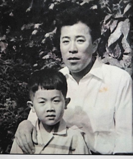 幼稚園に通っていたころの江蔵さん（左）と、育ての父（江蔵さん提供）