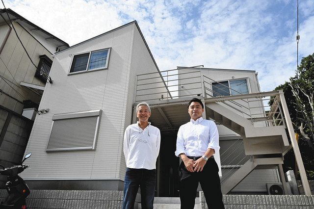 断熱性能の高い木造賃貸アパートの前で笑顔を見せる建築士の内山章さん（左）とオーナーの岩崎祐一郎さん＝横浜市鶴見区獅子ケ谷で