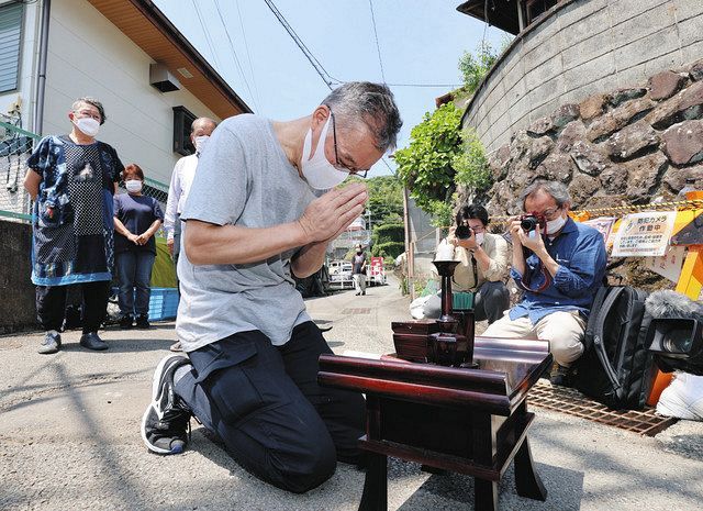 土石流で流された現場付近で線香を供える被災者＝熱海市で