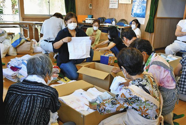 熊本県への支援物資として、タオル類を段ボールに詰め込む富崎地区の人たち＝館山市大神宮の富崎地区公民館で 