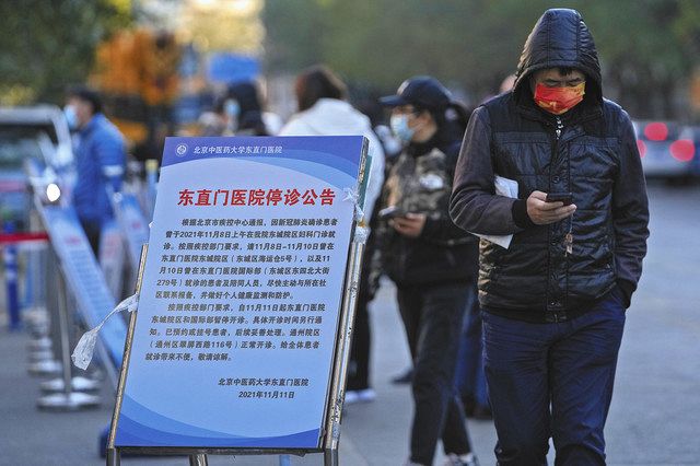 中国・北京の病院前で１１日、新型コロナウイルス陽性の患者が受診に訪れたため閉鎖中と記された告知板＝ＡＰ